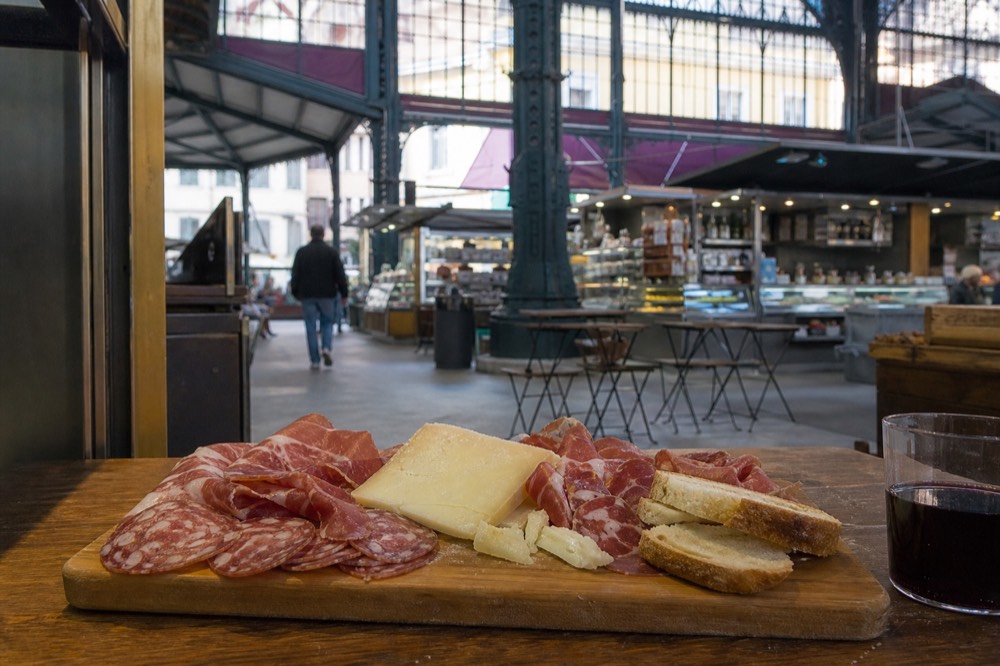 A tasting board of cured meats, cheese and bread on a wooden counter