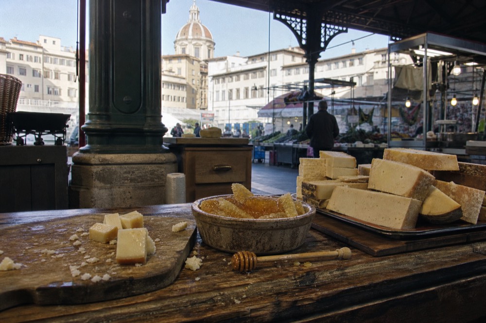 Trays of Tuscan cheese and honey arranged on a wooden market counter