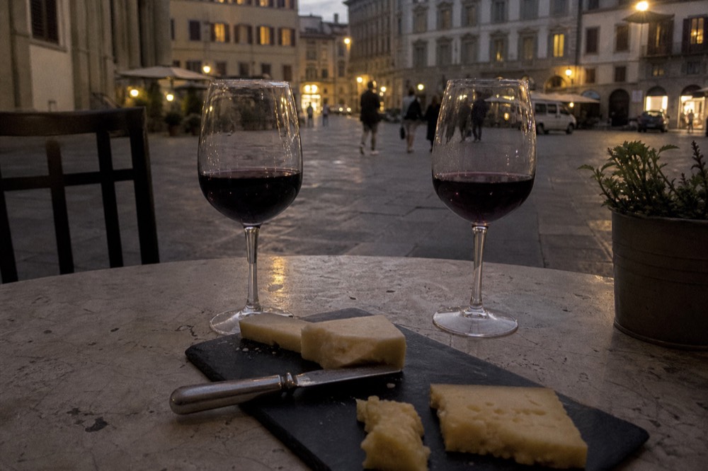 Glasses of red wine and plates of cheese on a Florence tasting counter