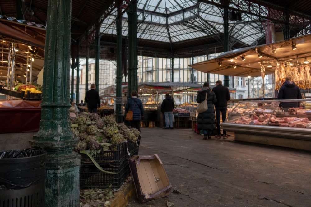 Interior of a historic Florence food market with stalls under an iron and glass roof
