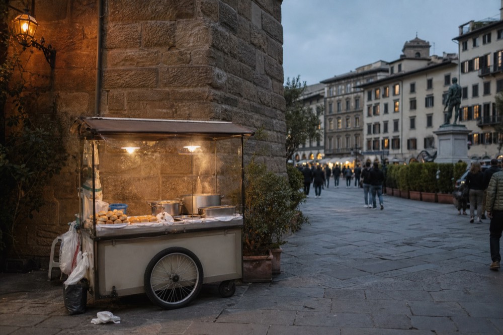 Street food cart with bread rolls and steaming pots on a Florence corner