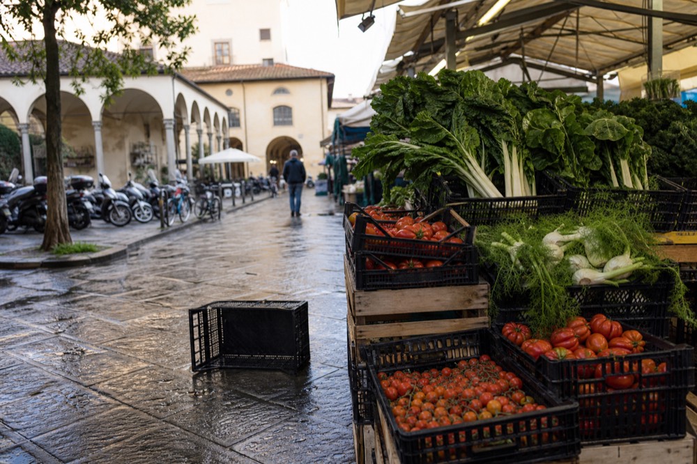 Fresh vegetables and leafy greens stacked in crates at an Italian market stall