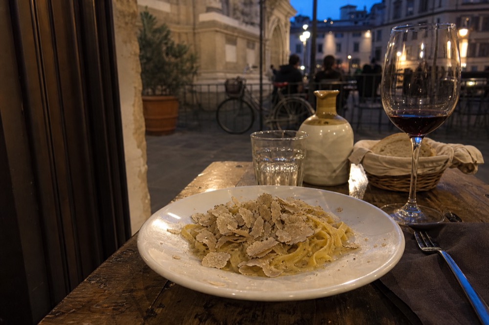 A plate of tagliolini pasta topped with shaved white truffle